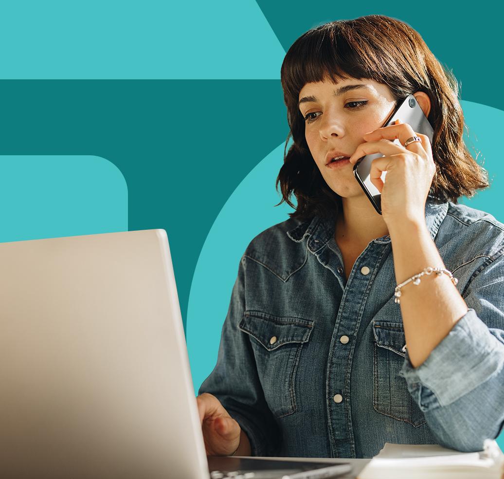 A person on a phone call while working on their laptop.