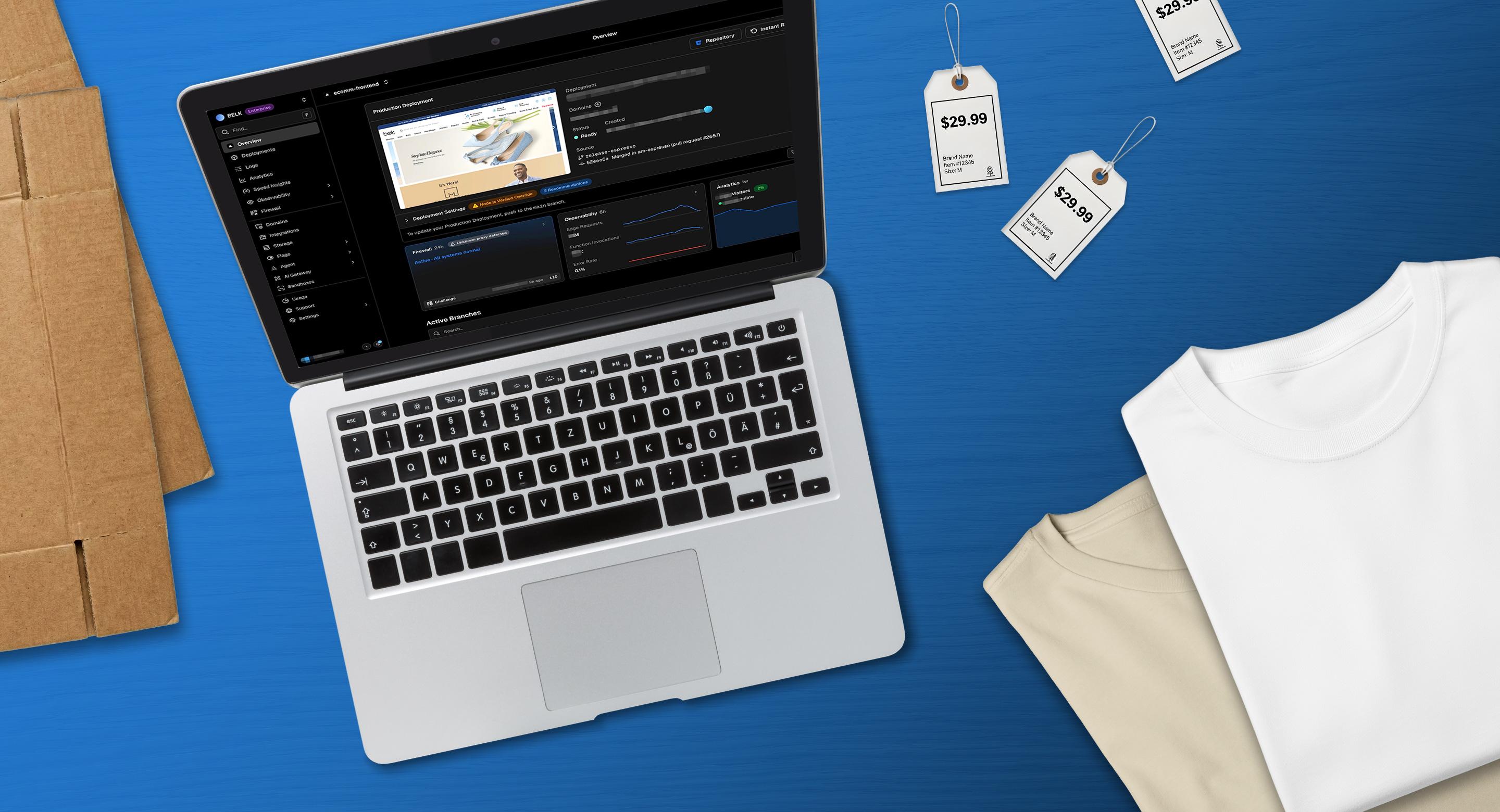 Laptop displaying a commerce analytics dashboard on a blue background, surrounded by folded t-shirts and price tags—representing retail merchandising and e-commerce operations.