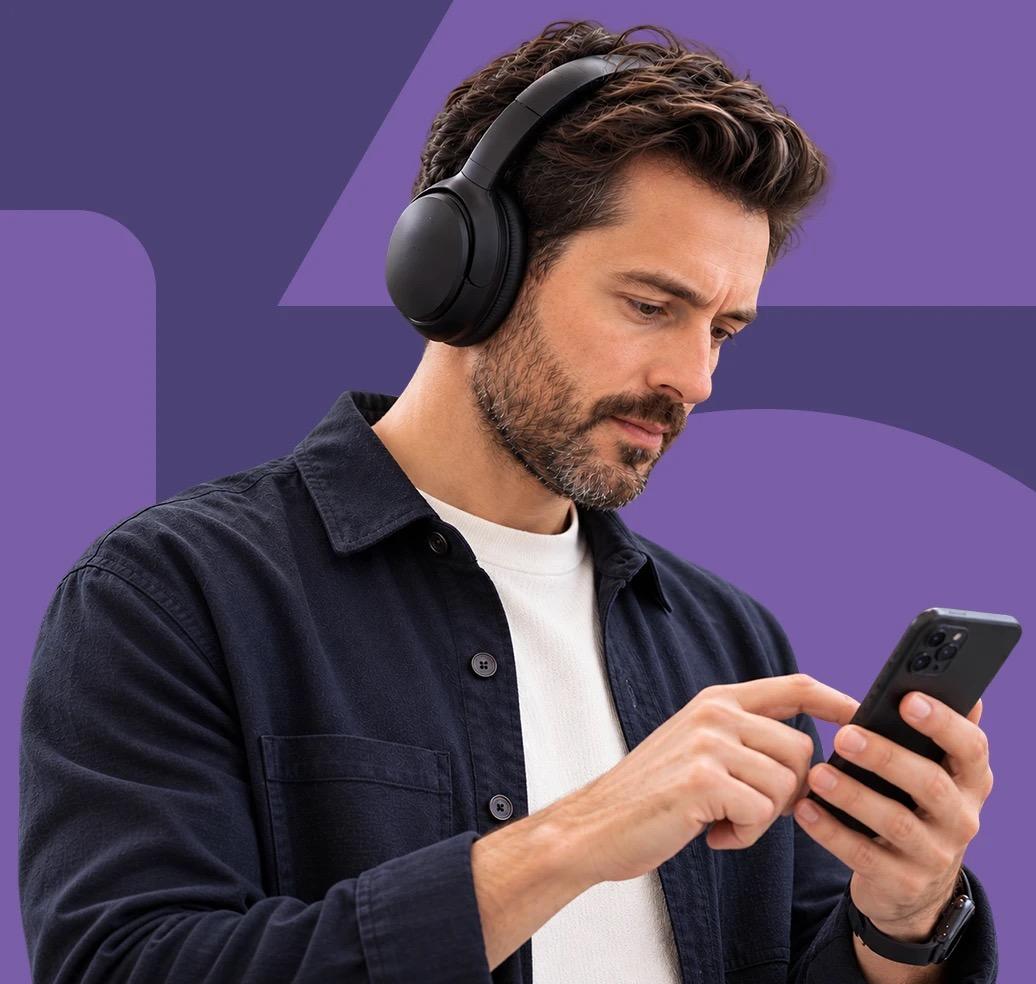 Un hombre con audífonos revisando resultados en su teléfono.