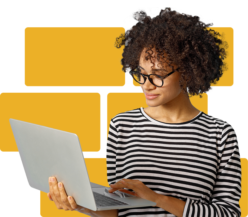 A woman wearing glasses and looking down at their laptop.