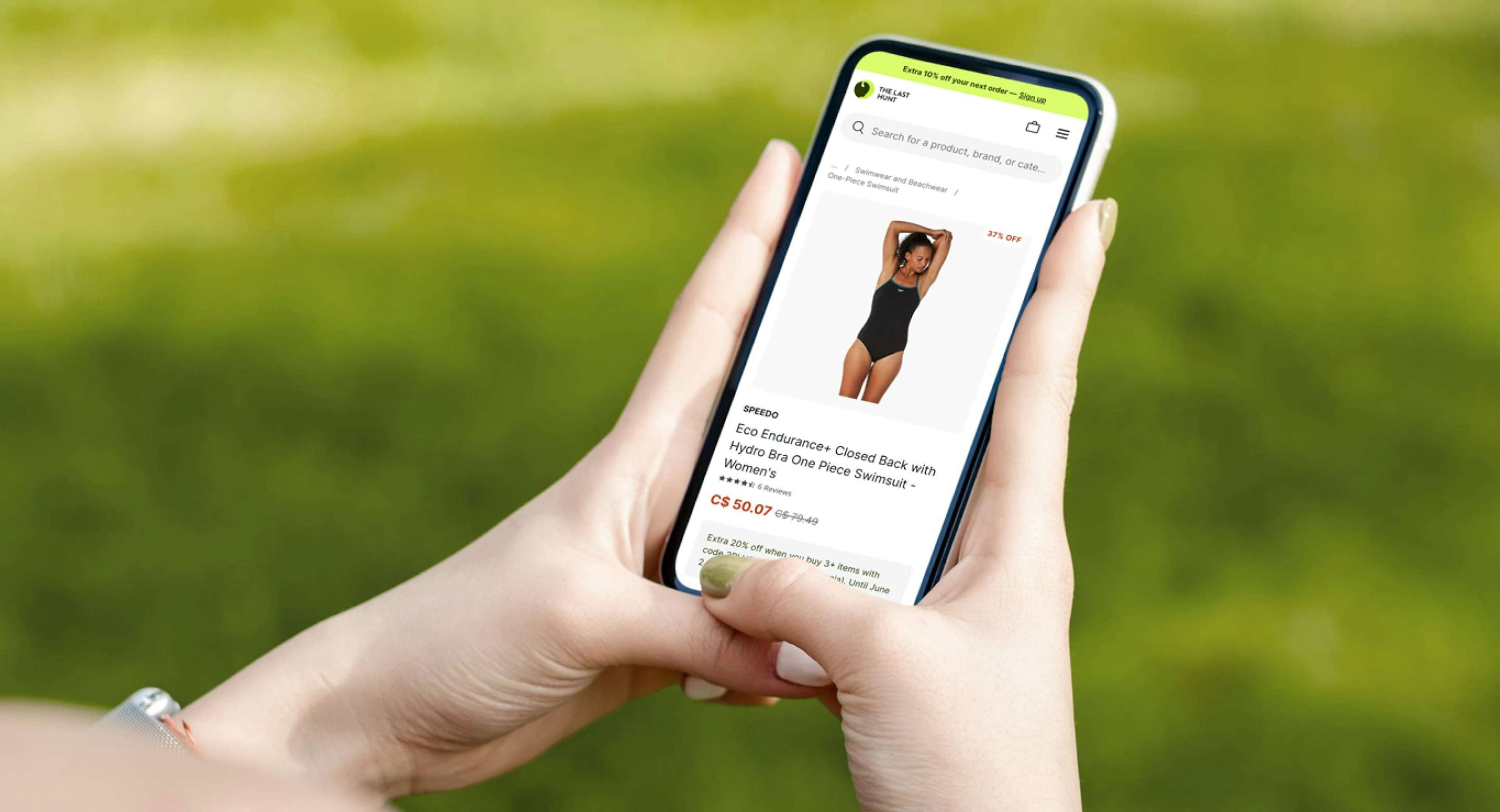 A person holding a smartphone looking at a Speedo bathing suit's product detail page.