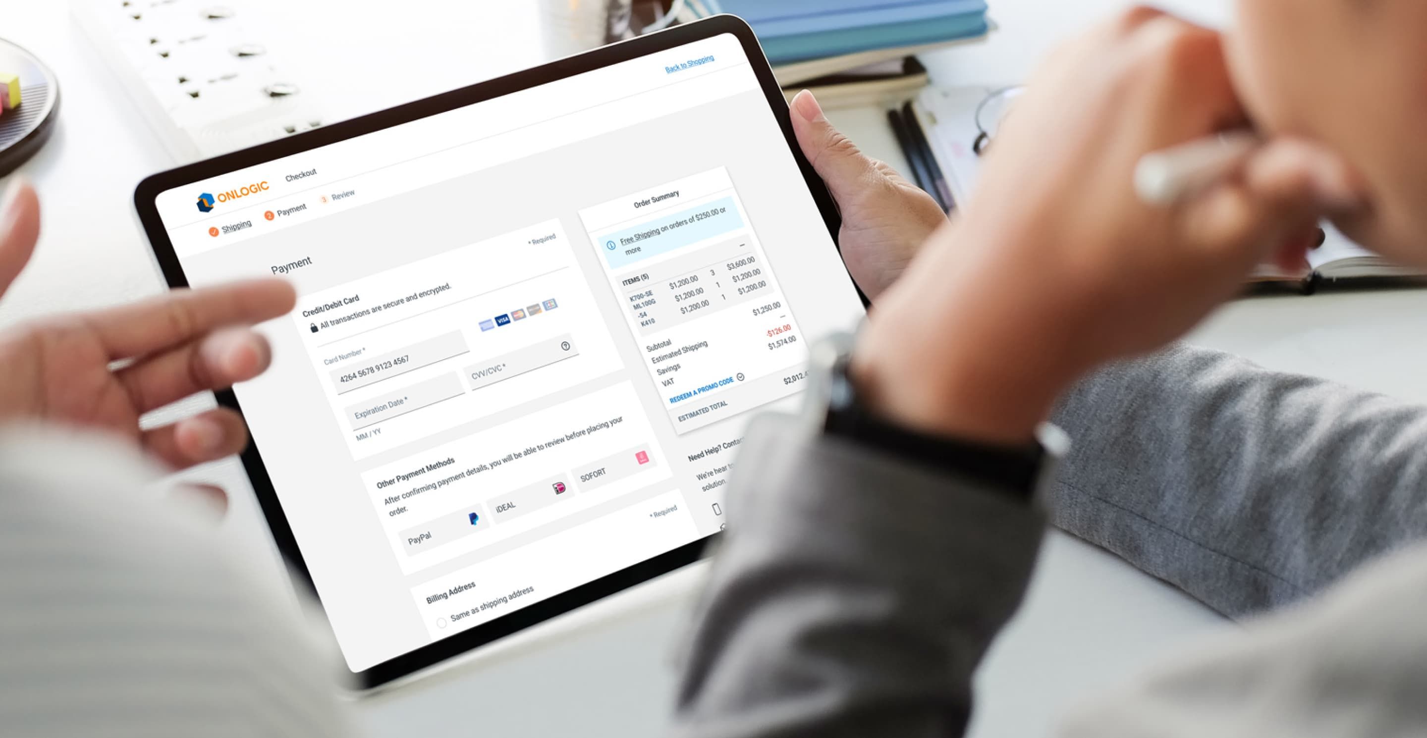 An iPad with the OnLogic checkout and payment screen on display, showing the order summary and costs as well as credit card fields.