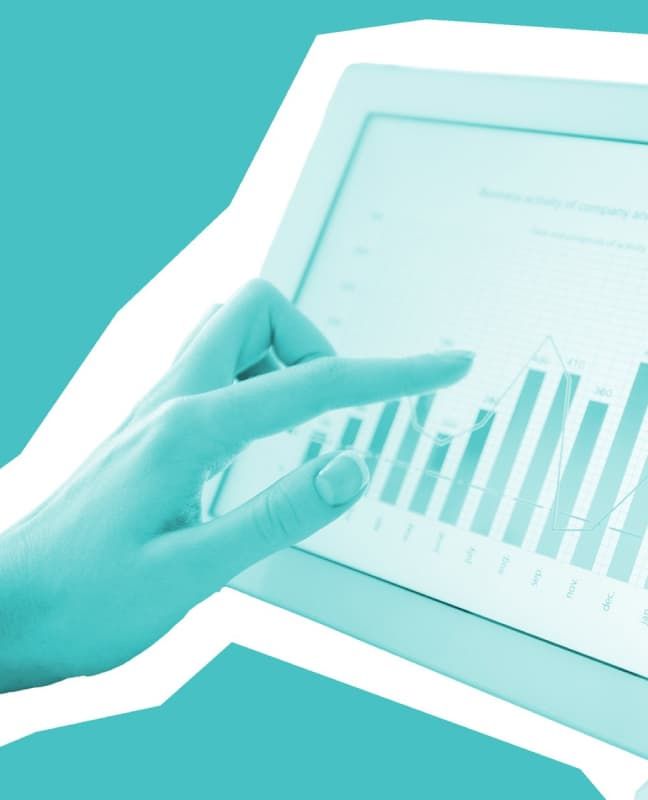 A hand in front of a touchscreen displaying a bar and line graph.