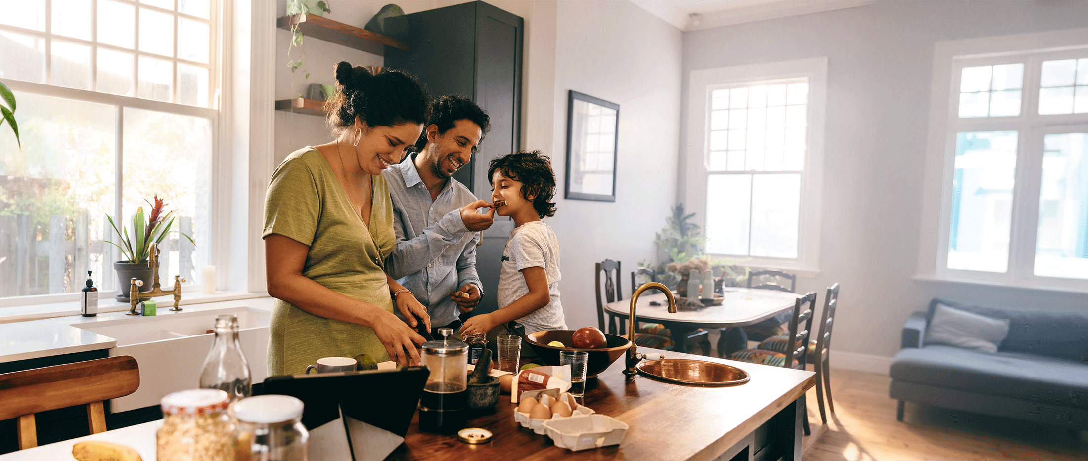Family making and eating food at a table.