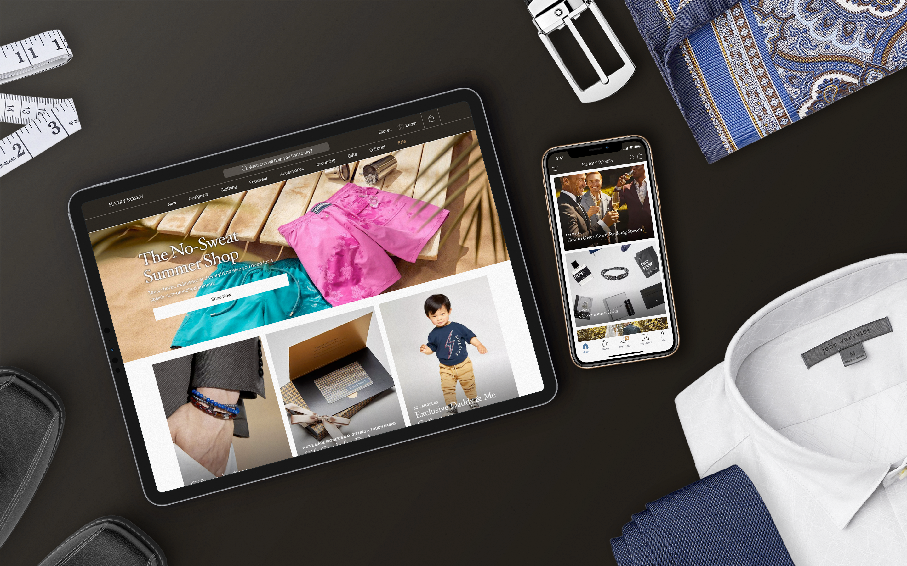 Flatlay of Harry Rosen website on an iPad and iPhone with clothing and accessories around the devices.