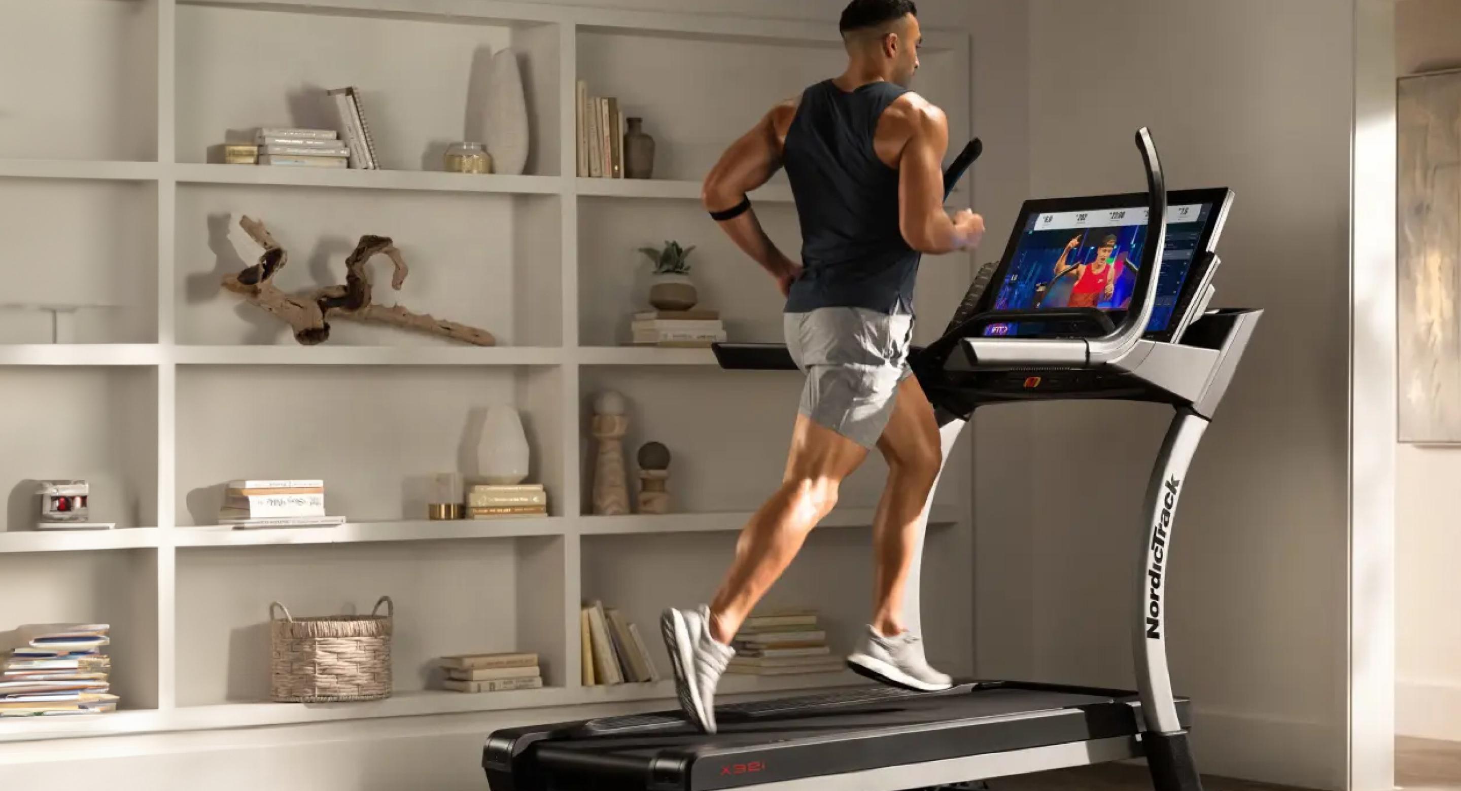 A photo of a man running on a NordicTrack treadmill in a living room.