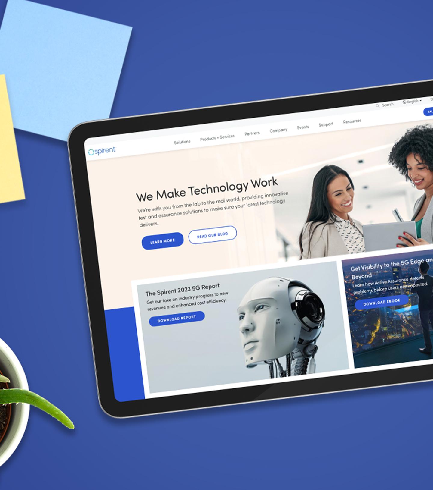 Una tablet mostrando el sitio web de Spirent sobre un fondo azul.