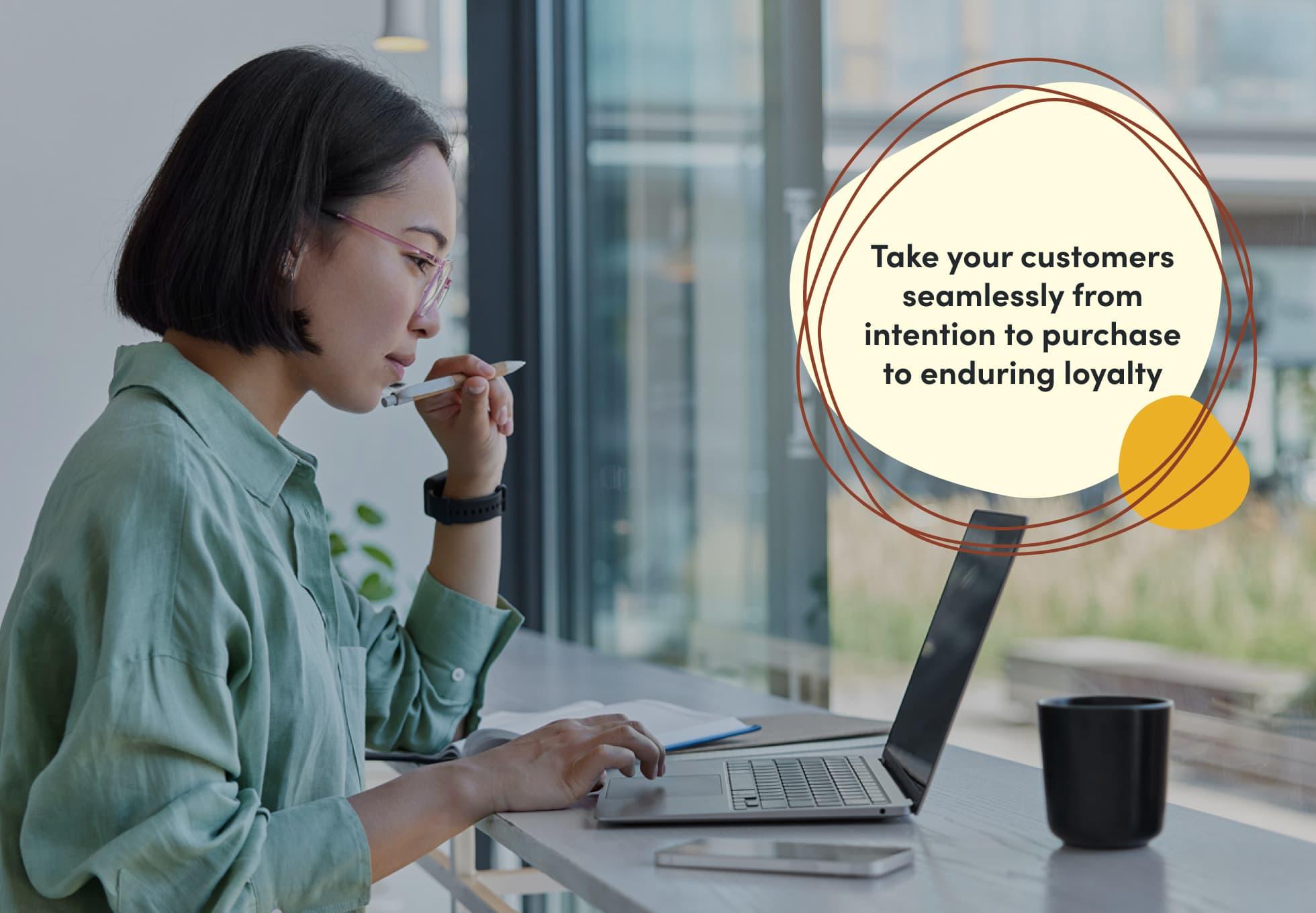 A person is sitting at a desk and looking at their laptop in a thoughtful manner. The sentence imposed on the image says, "Take your customers seamlessly from intention to purchase to enduring loyalty."