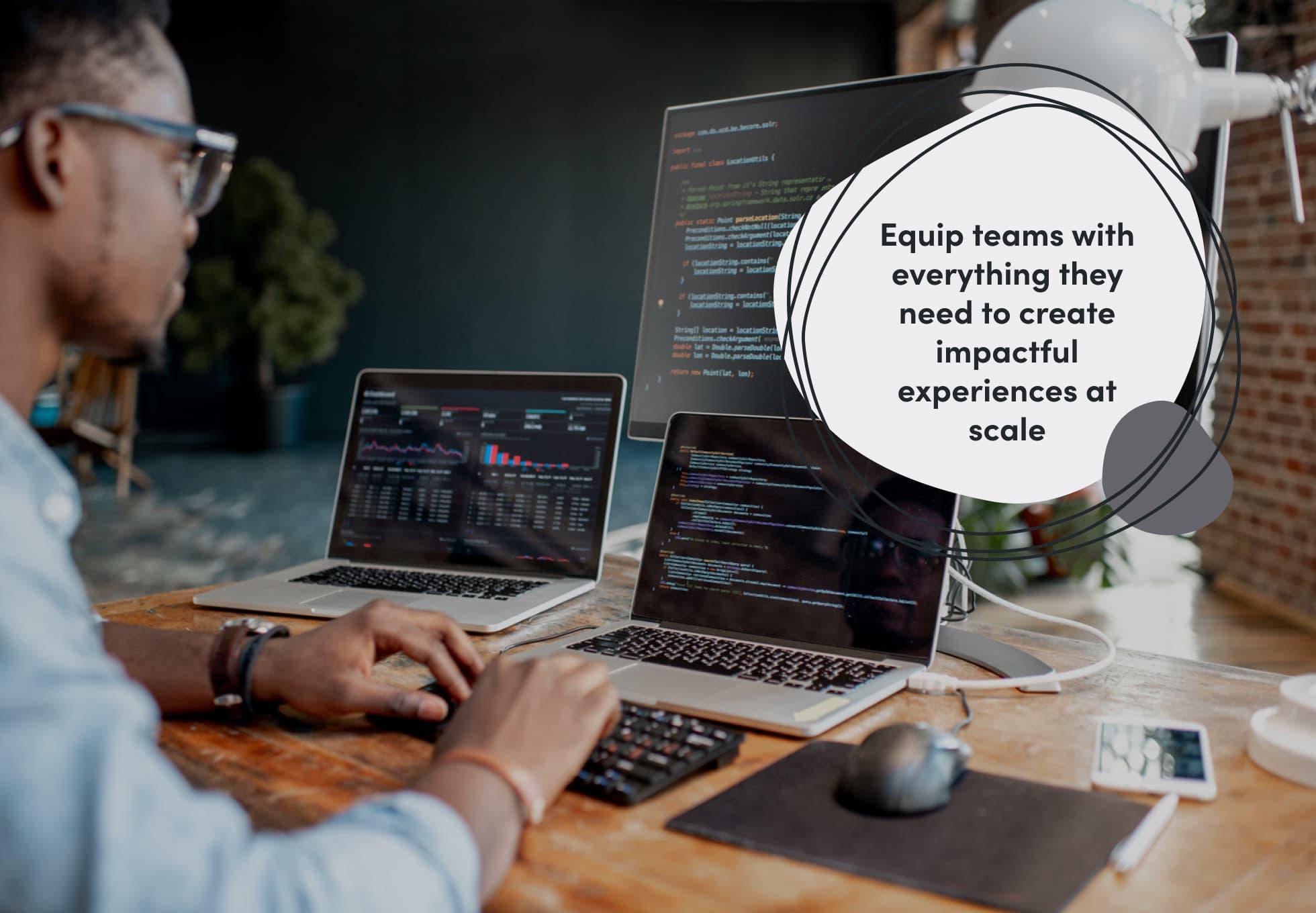 A person working on code on two laptops and a monitor. Overtop this image says "Equip teams with everything they need to create impactful experiences at scale."