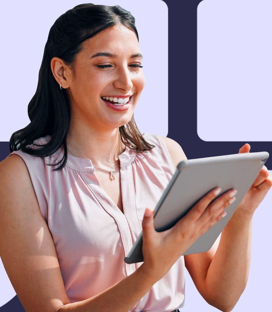 A woman is looking at an iPad and smiling at the display.