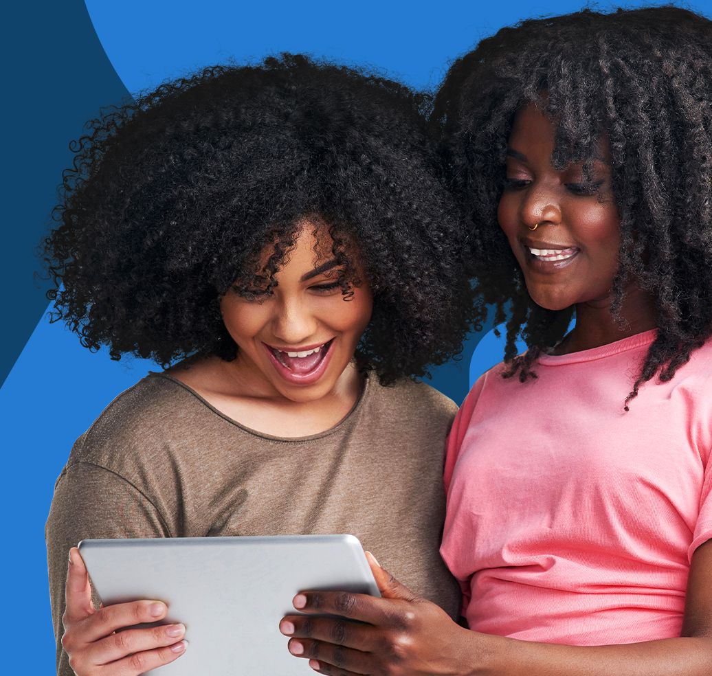Two colleagues smiling and looking at an iPad screen with enthusiasm.