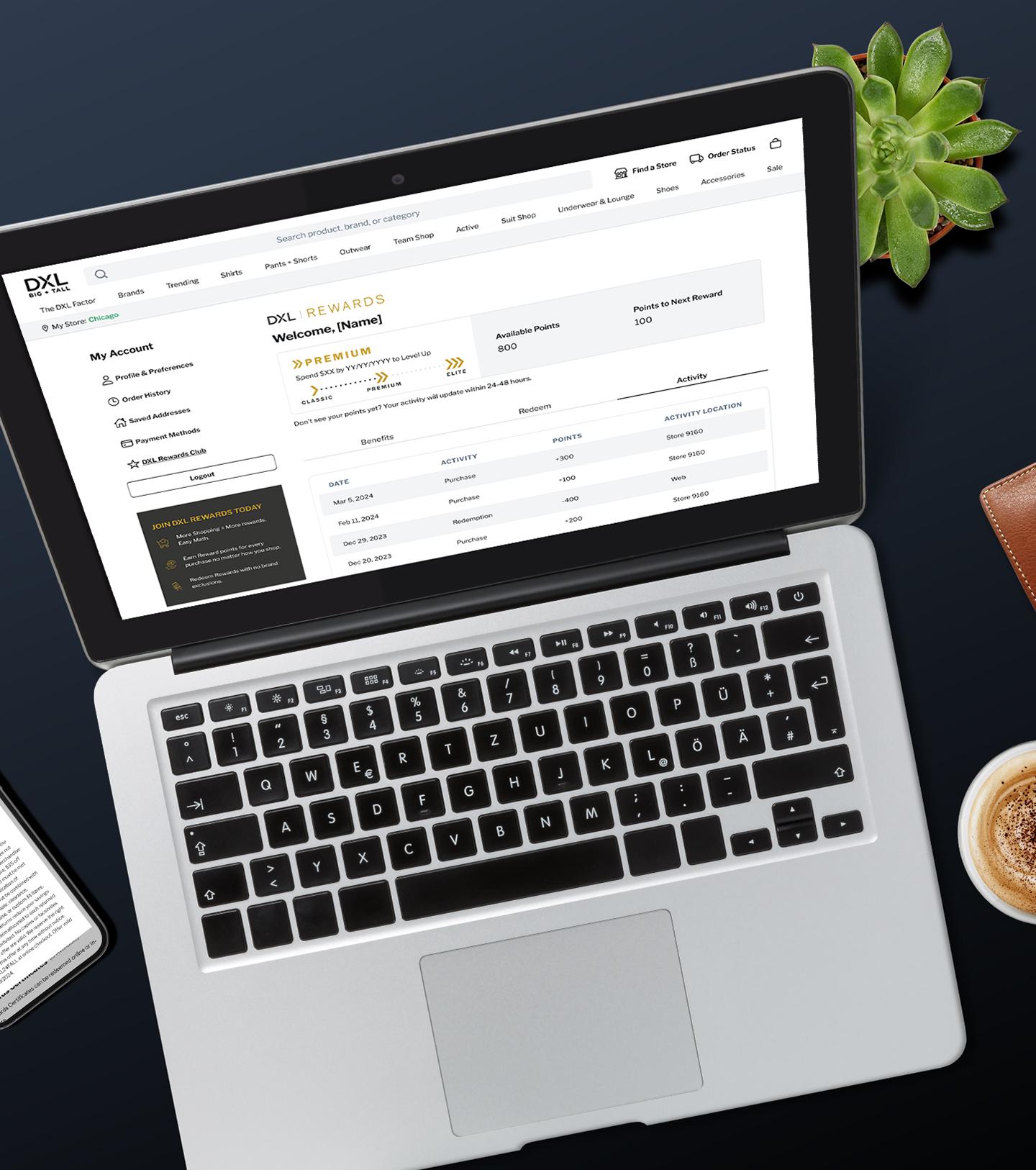 A close-up of a laptop showing a DXL rewards dashboard, with a succulent, leather wallet, and cup of coffee nearby on a dark surface.