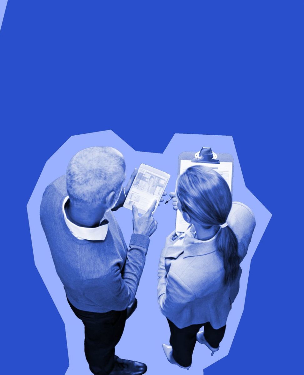 View of two people from above. They are both holding clipboards and papers.