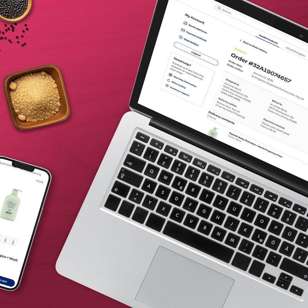 Laptop showing an HSA/FSA-eligible order details page for baby shampoo, with a matching phone screen and small bowls of beauty product ingredients on a magenta background.