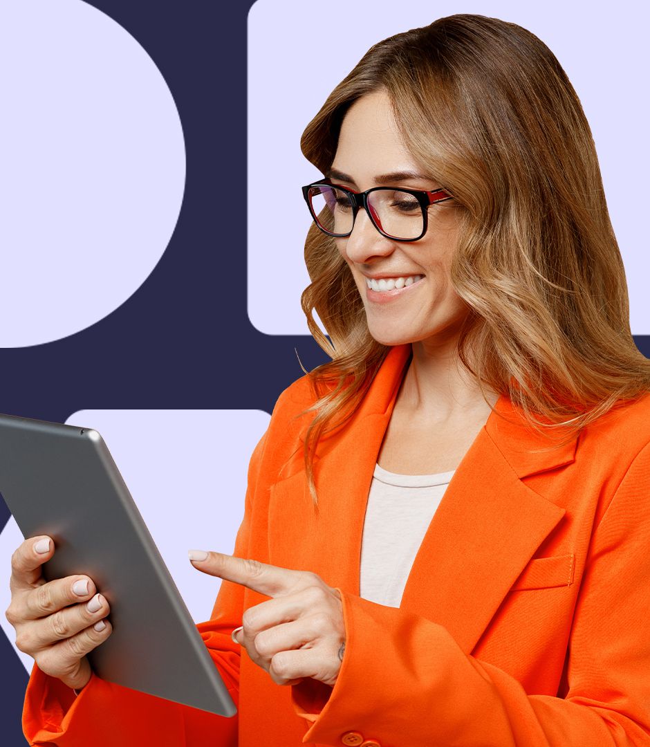A woman in glasses and a bright orange blazer smiles while looking at a tablet screen. She appears to be about to interact with something on the screen.